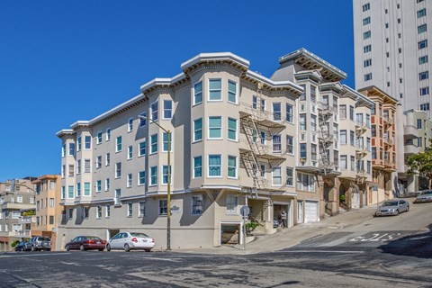 A row of multi-story buildings with a clear blue sky above.