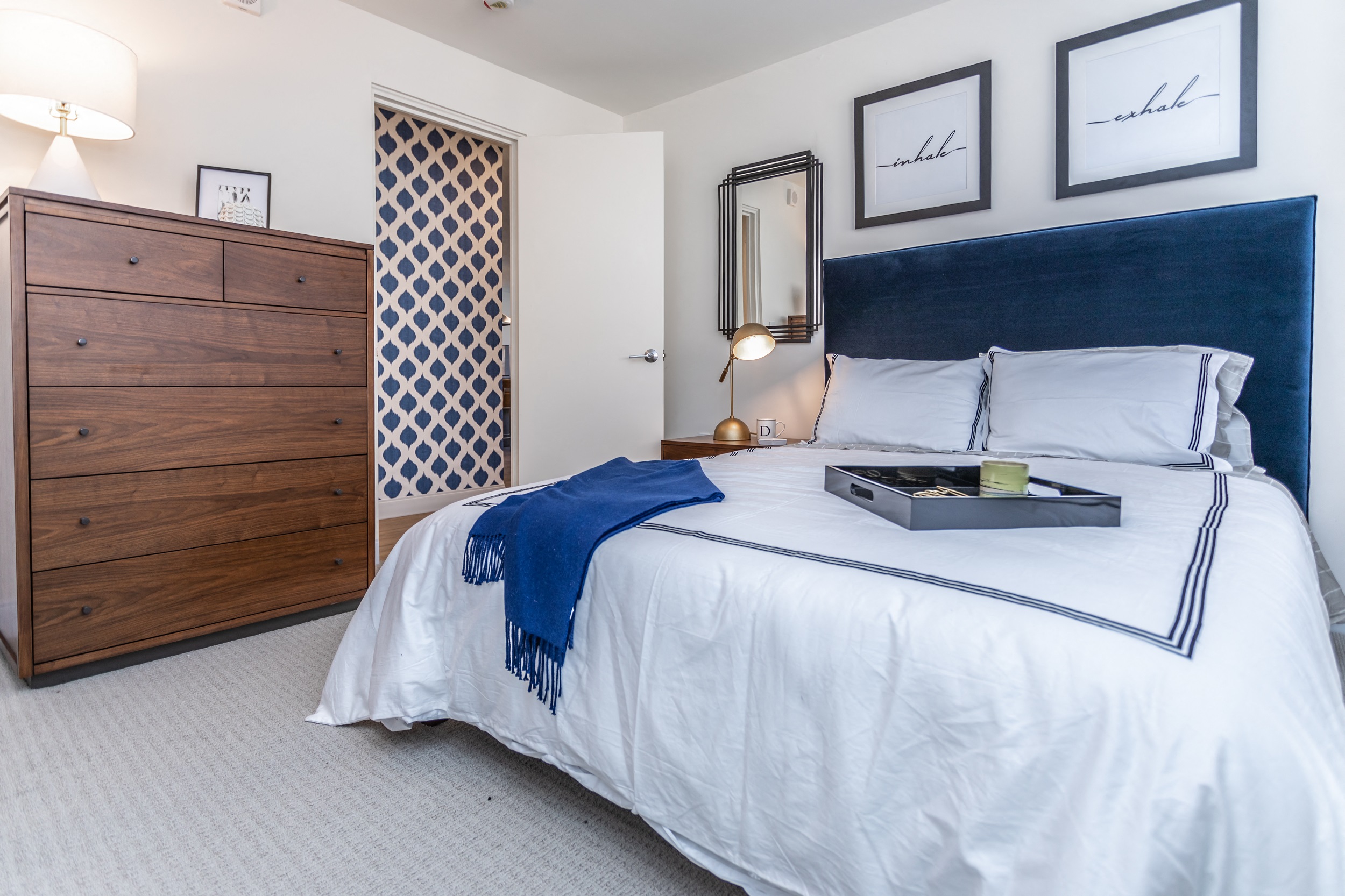 Spacious apartment bedroom with carpet flooring and white walls