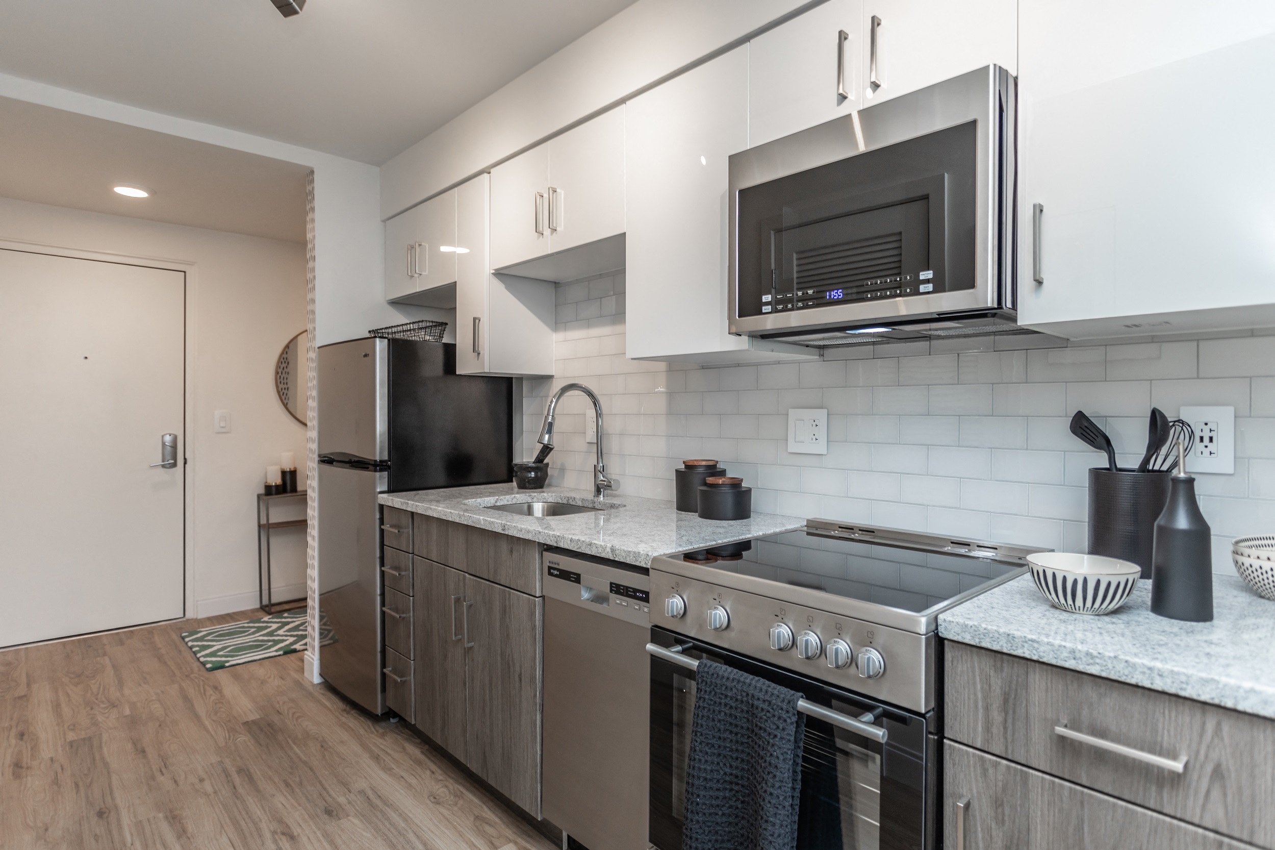 Stainless steel appliances and two-tone cabinets in contemporary Philadelphia apartment kitchen