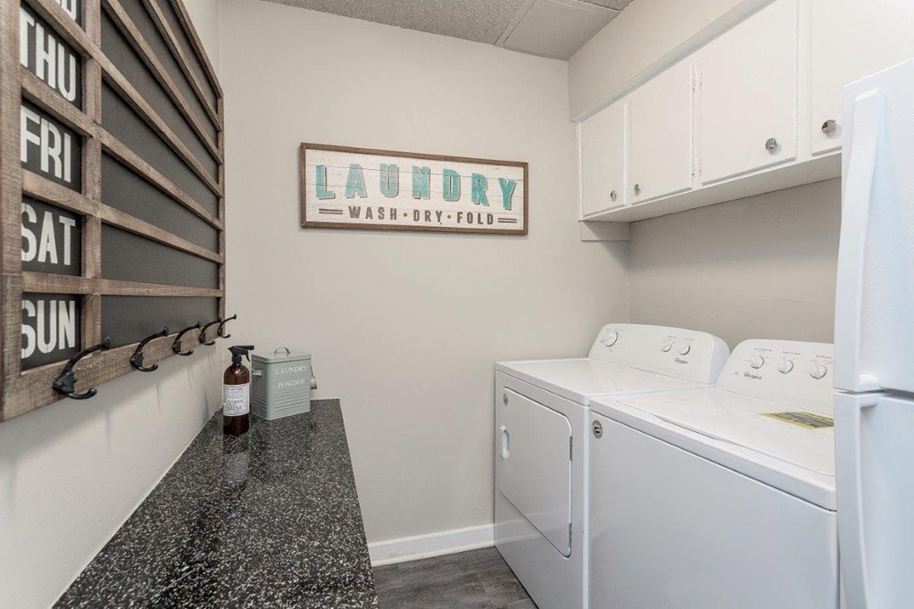 a laundry room with a washer and dryer and a counter with a sink