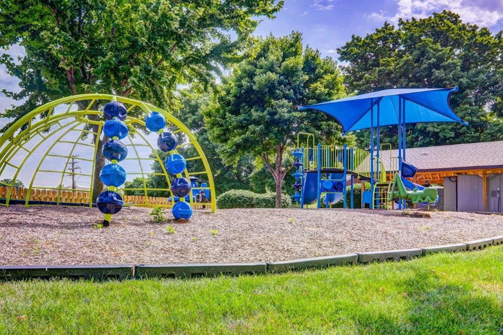 a playground with a swing set and a umbrella