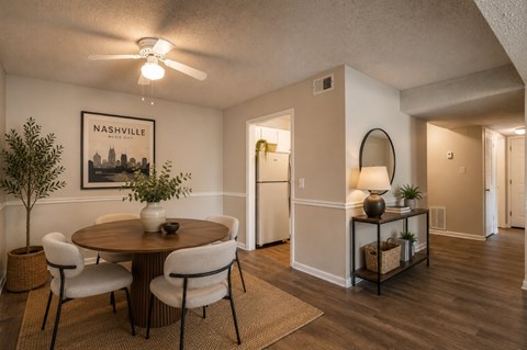 A dining room with a round table and chairs.