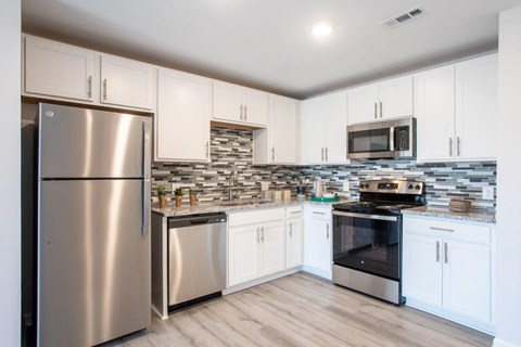 a kitchen with stainless steel appliances and white cabinets