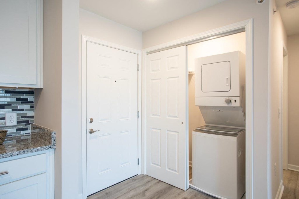 a kitchen with white cabinets and a refrigerator and a microwave