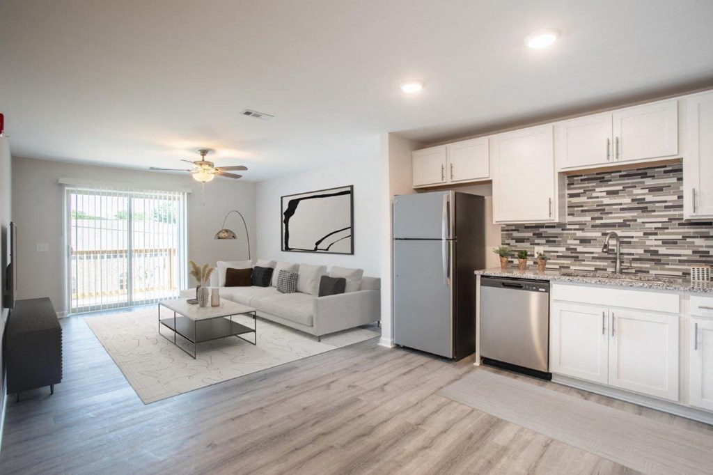 a kitchen and living room with a refrigerator and a couch