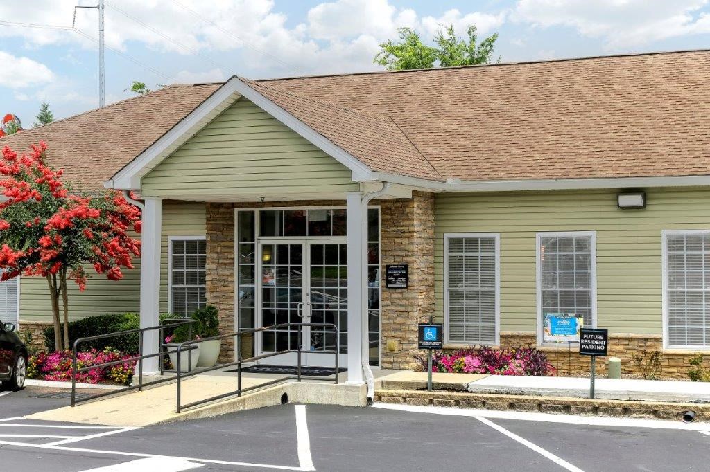 the front entrance of a building with a parking lot