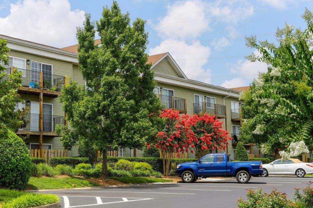a blue truck parked in front of an apartment building