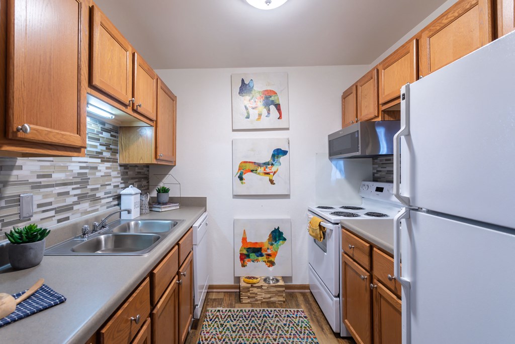 a kitchen with white appliances and wooden cabinets