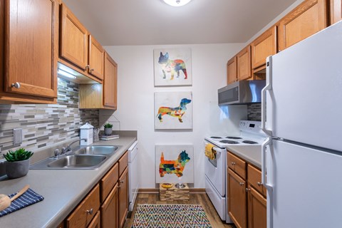 a kitchen with white appliances and wooden cabinets