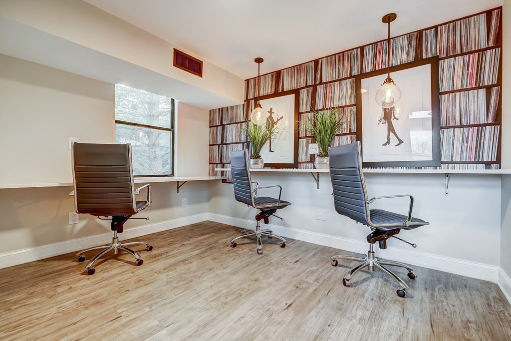 two chairs in an office with a desk and windows