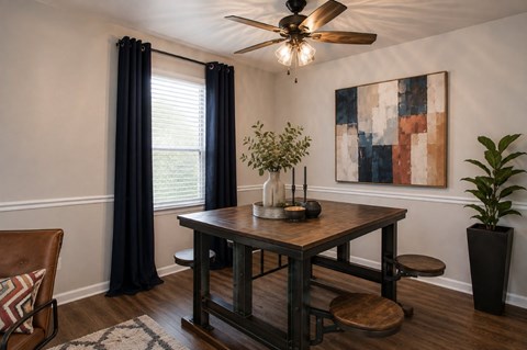 A dining room with a wooden table and chairs.