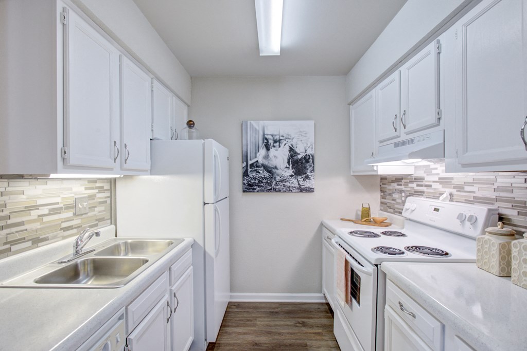 a white kitchen with white appliances and white cabinets