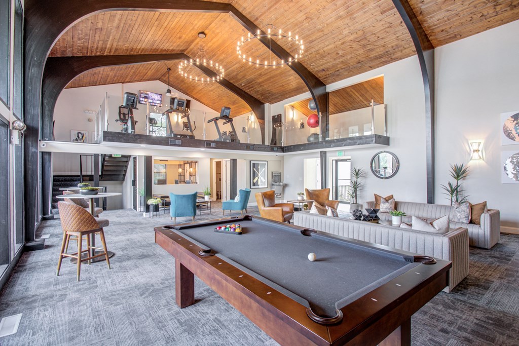 a spacious living room with a pool table      and a bar