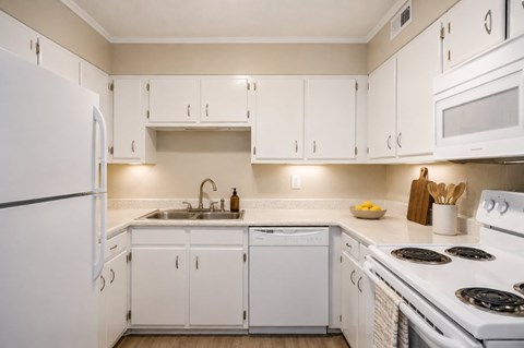 A white kitchen with a refrigerator on the left and a stove on the right.