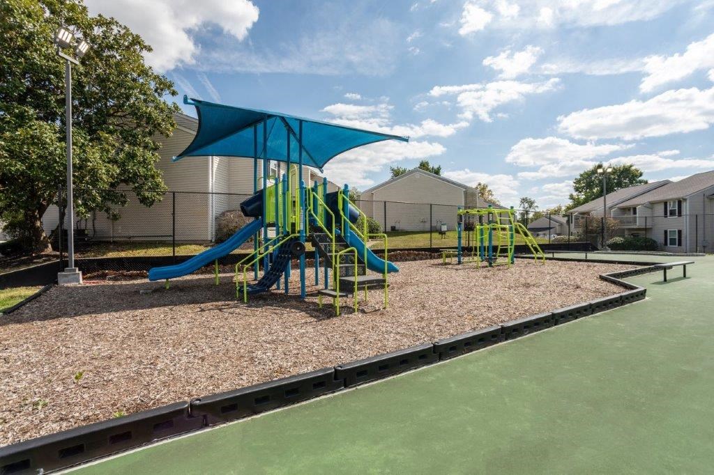 a playground with a blue and yellow swing set