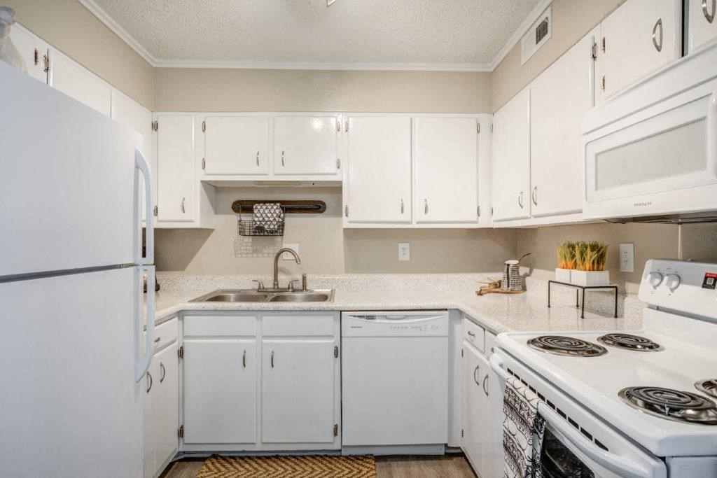 a white kitchen with white appliances and white cabinets