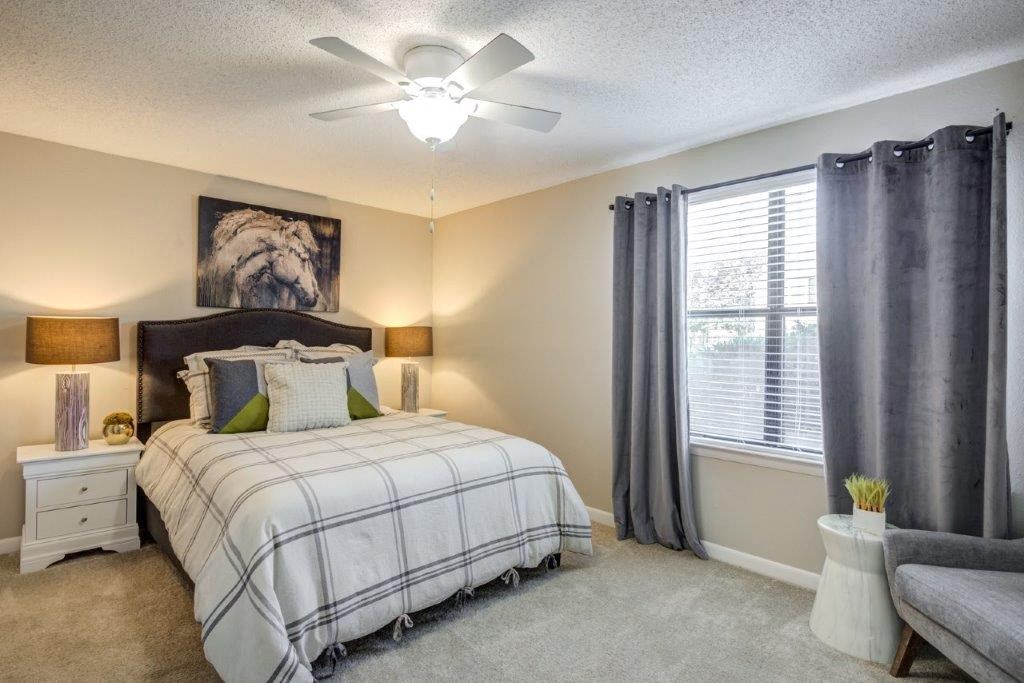 a bedroom with a bed and a ceiling fan