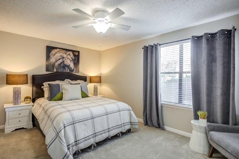 a bedroom with a bed and a ceiling fan