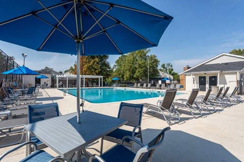 our apartments have a pool and tables with chairs and umbrellas