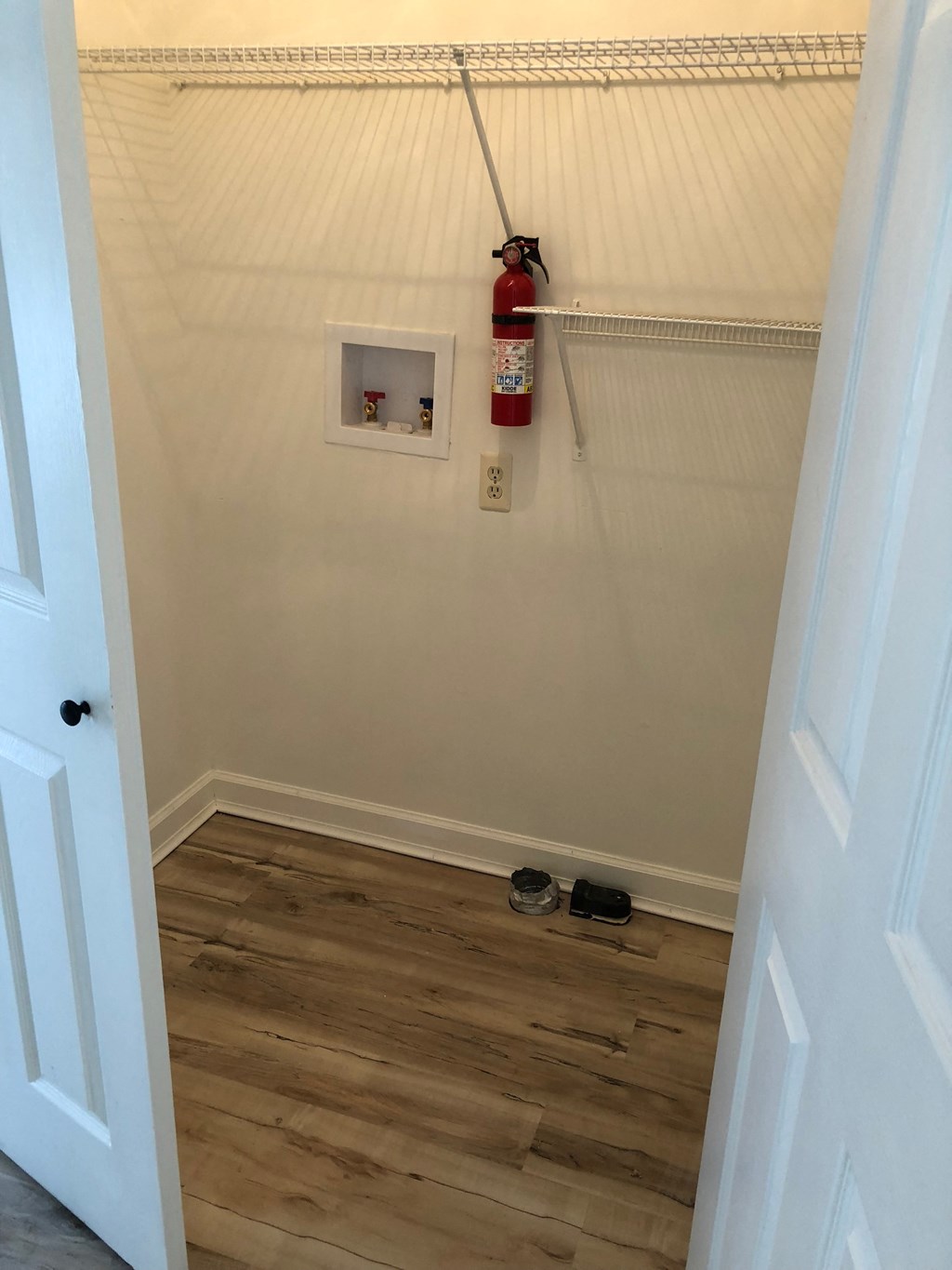 a small room with a fire hydrant on the wall and wooden floors