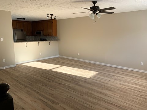 A room with wooden flooring and a ceiling fan.