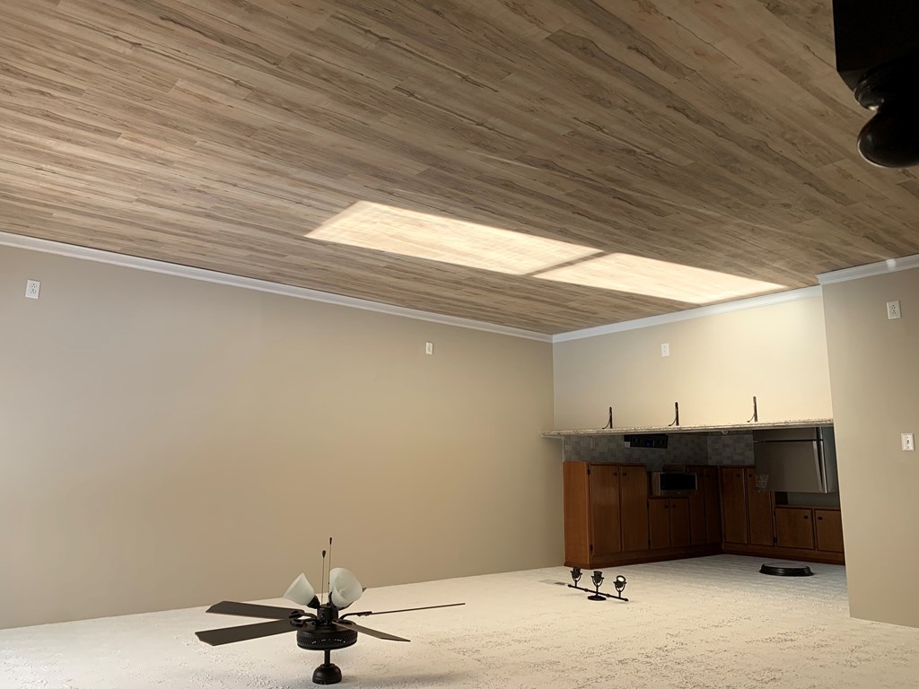 a living room with a ceiling with a wooden ceiling and a ceiling fan