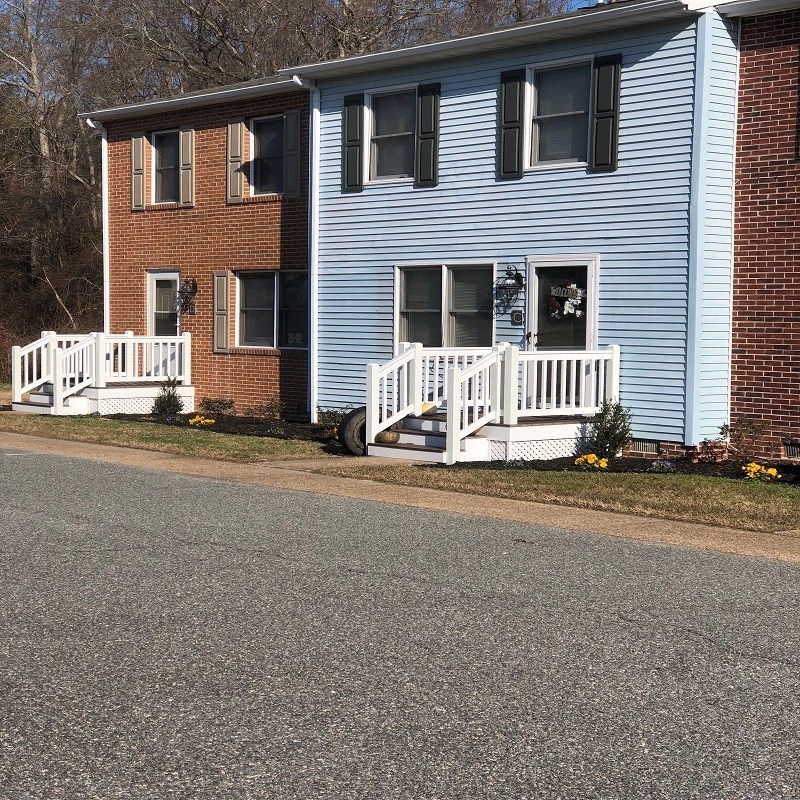 a blue house with a white fence in front of it