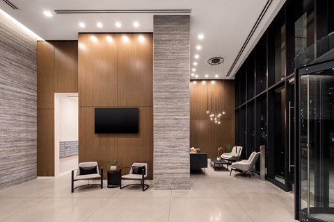 a lobby with chairs and a tv on the wall