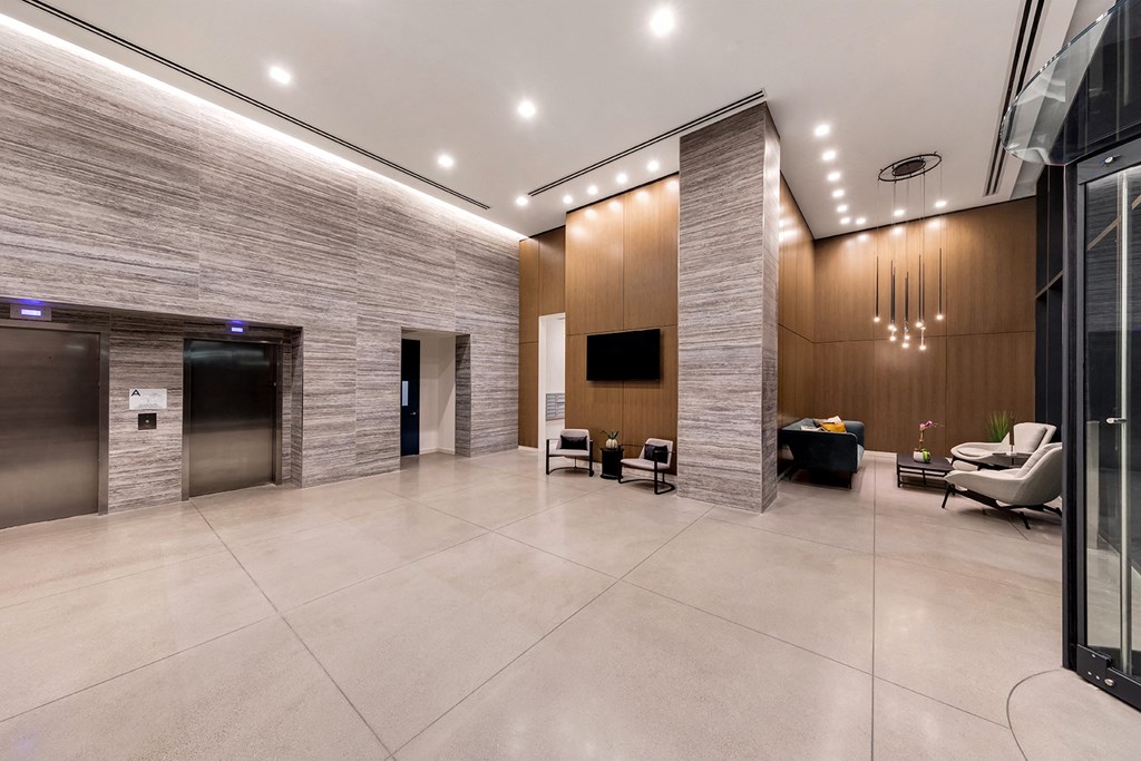 a large lobby with chairs and a tv