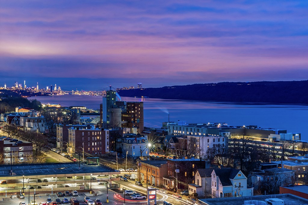 a city at night with the water in the background