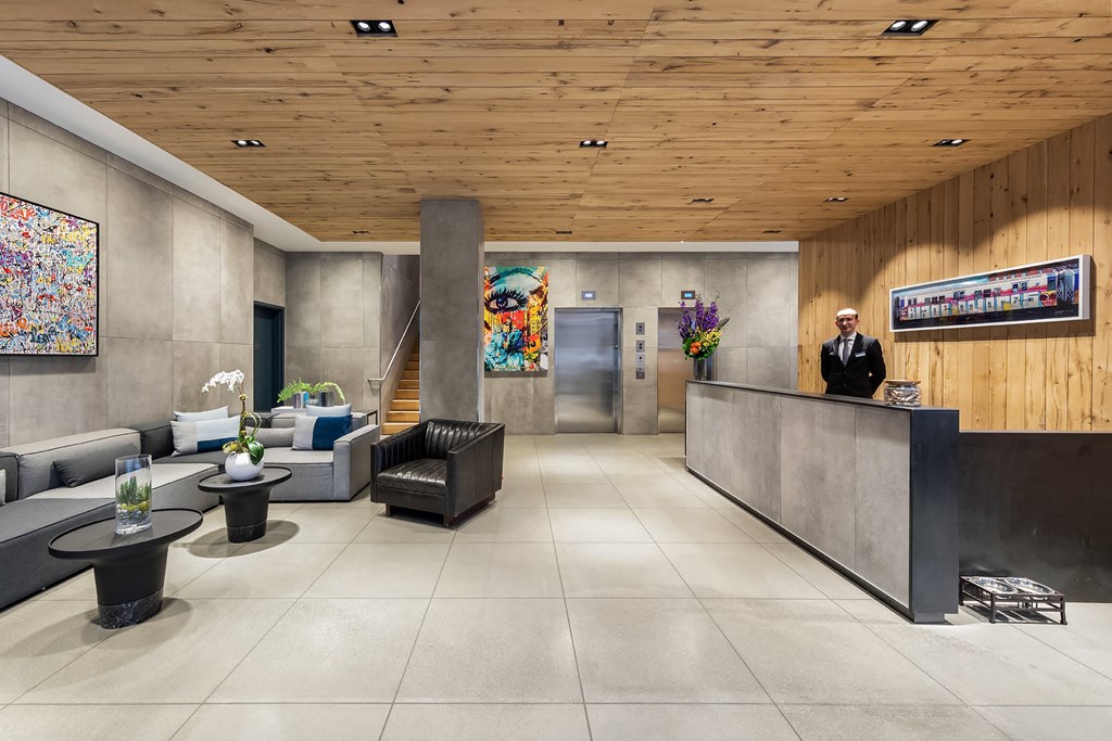 the lobby of a hotel with a man standing at the reception desk