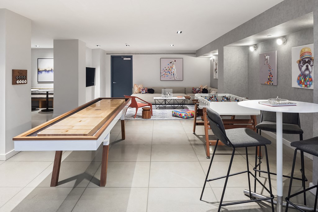 a living room with a bar and a dining room with tables and chairs