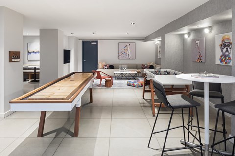 a living room with a bar and a dining room with tables and chairs
