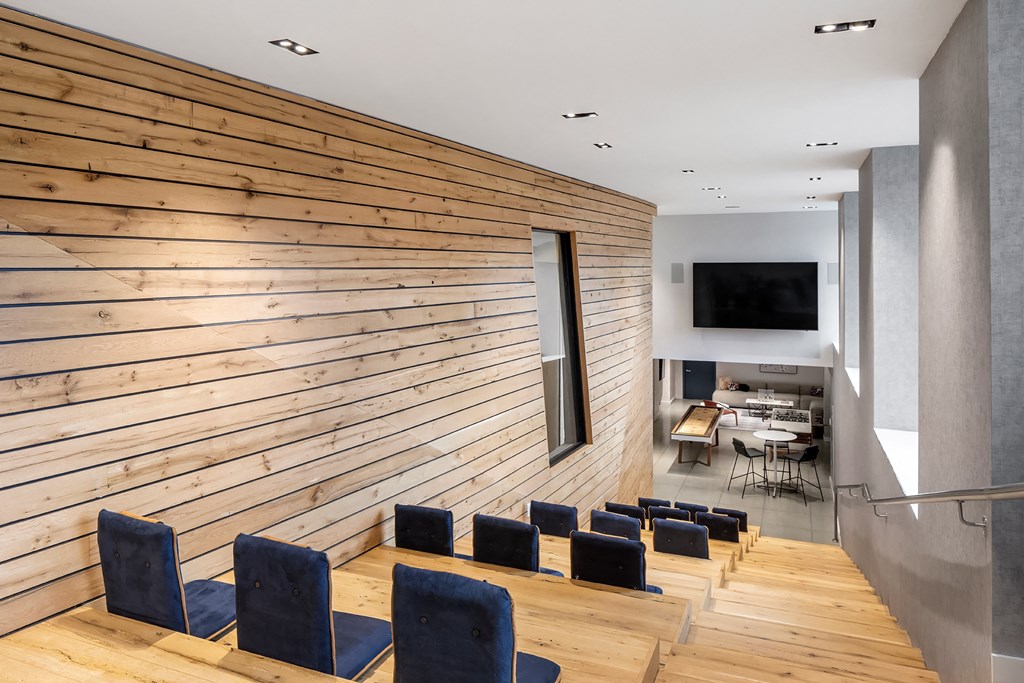 a conference room with blue chairs and a wooden wall