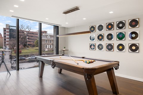 a games room with a pool table and a wall of records