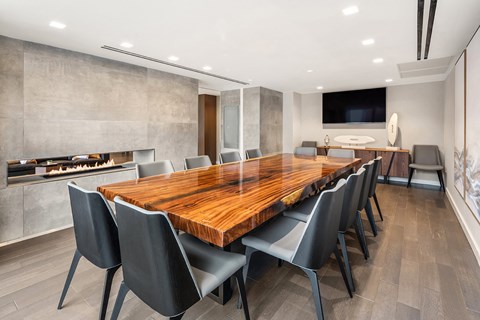 a large dining room with a long wood table and chairs