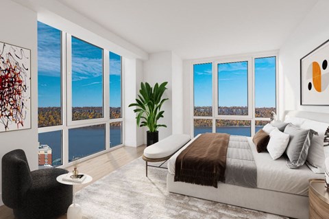 an open bedroom with a bed and a view of the city and the ocean