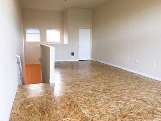 an empty living room with plywood on the floor