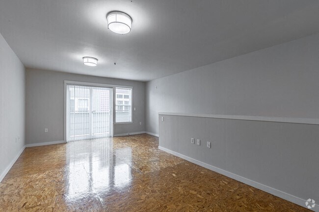 an empty living room with white walls and a door