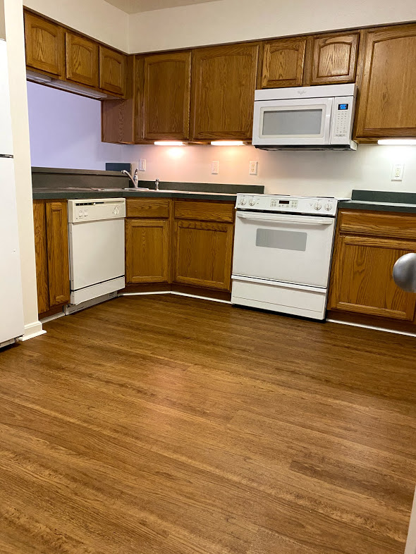 Silver Mill Apartments - Kitchen / Electric range / Build-in Microwave / Dishwasher / Refrigerator / Wood-grain cabinets / Under-cabinet lighting / Wood-grain, vinyl plank flooring