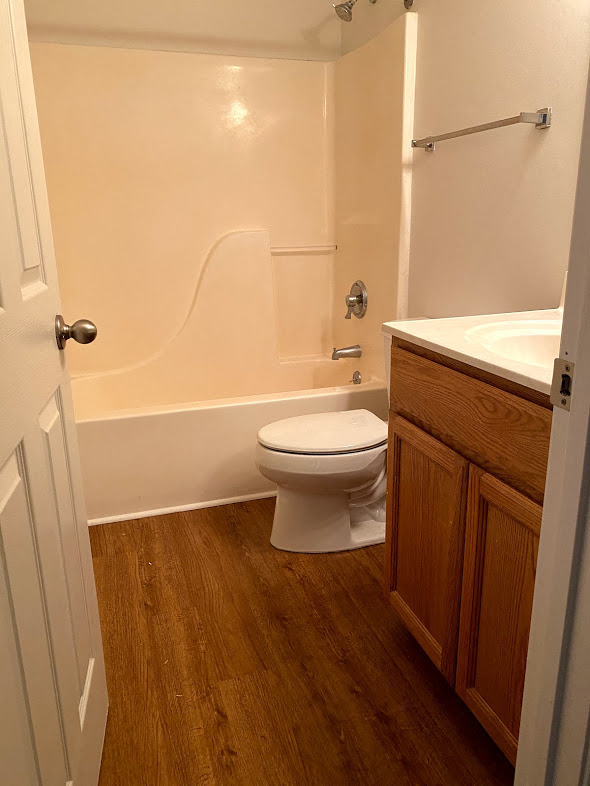 Silver Mill Apartments - Full Bathroom in Hallway / Bathtub / Vanity / Wood-grain, vinyl plank flooring