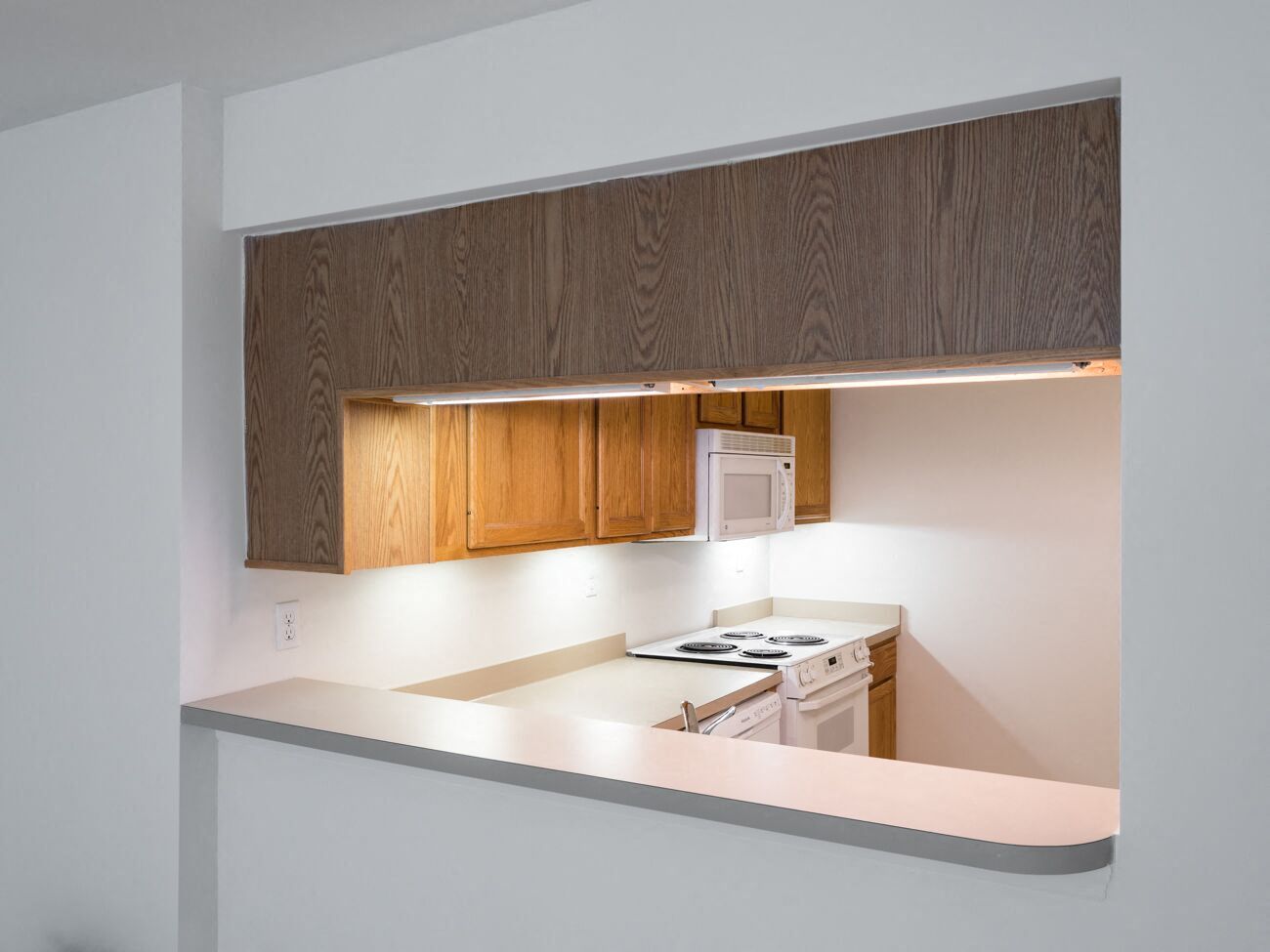 Silver Mill Apartments - Pass-thru from Kitchen to Living/Dining room / Electric range / Built-in Microwave / Dishwasher / Wood-grain cabinets / Under-cabinet lighting