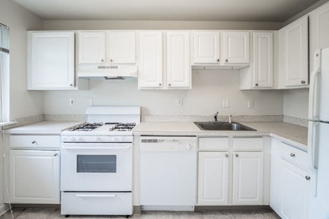a white kitchen with white appliances and white cabinets