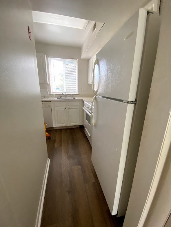 Westfalen Apartments - Kitchen / Kitchen window over sink / Refrigerator / Dishwasher / Gas Range / Wood-grain, vinyl plank flooring