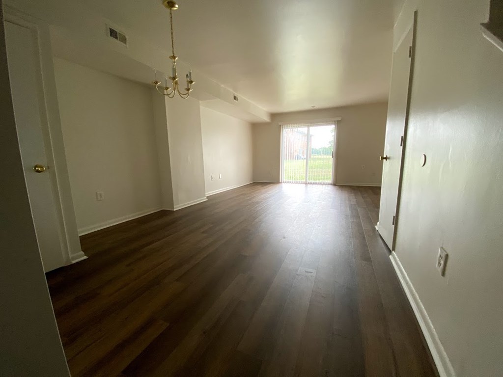 Westfalen Apartments - Dining room / Living room / sliding-glass door to patio / wood-grain, vinyl plank flooring