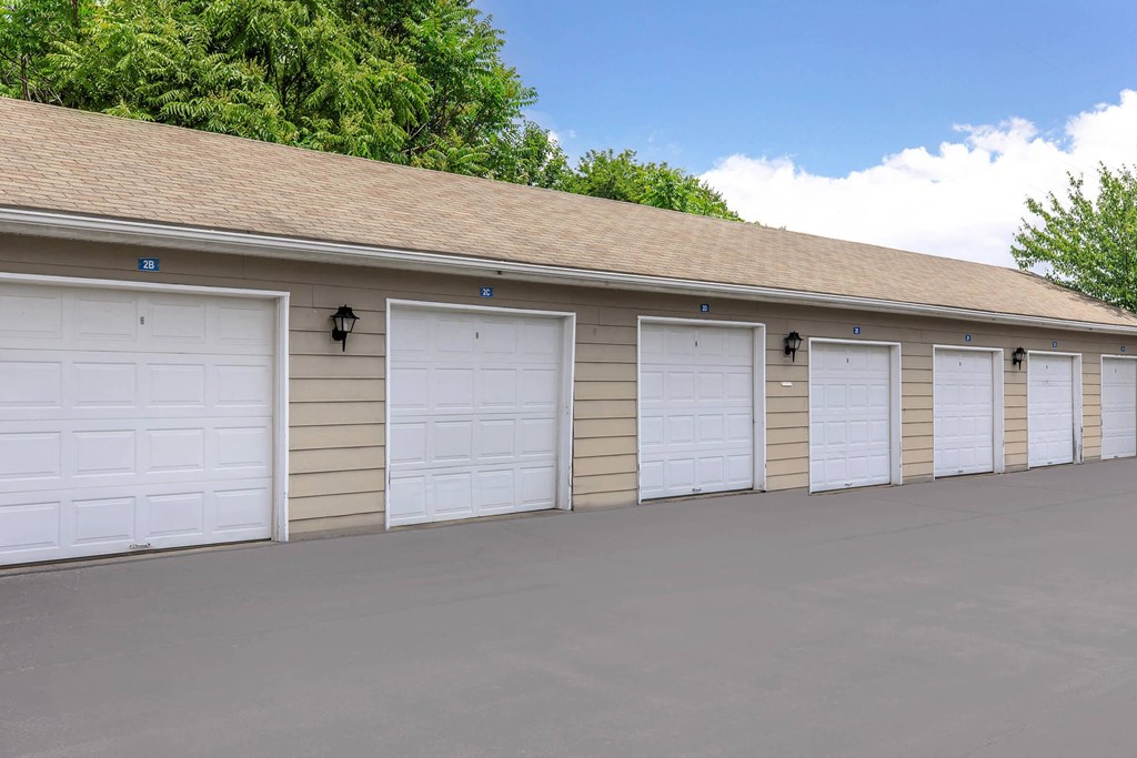 a row of white garage doors on the side of a building