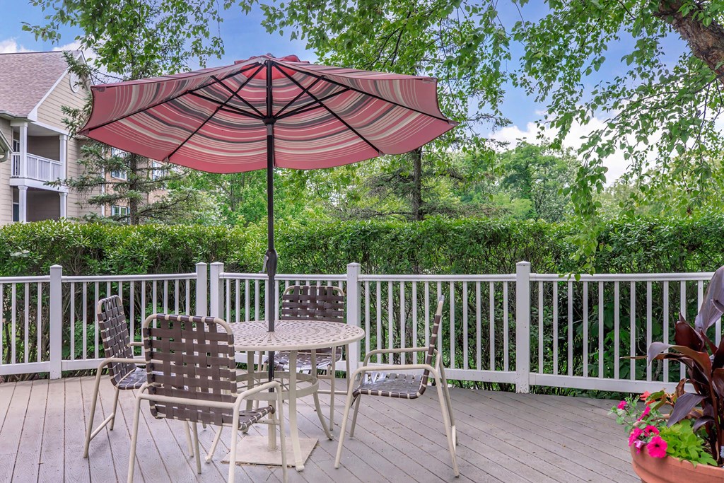 a patio with an umbrella and a table with chairs