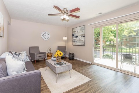 a living room with a ceiling fan and a sliding glass door
