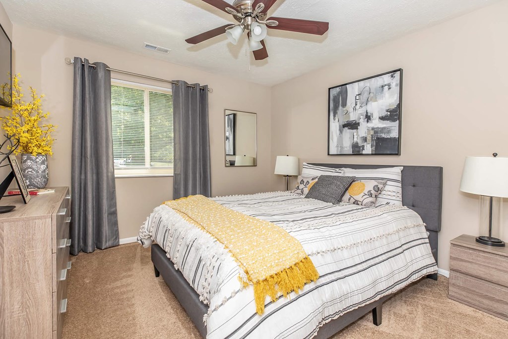 a bedroom with a bed and a ceiling fan