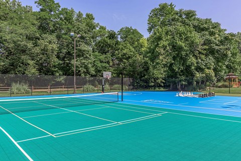 two tennis courts with trees in the background